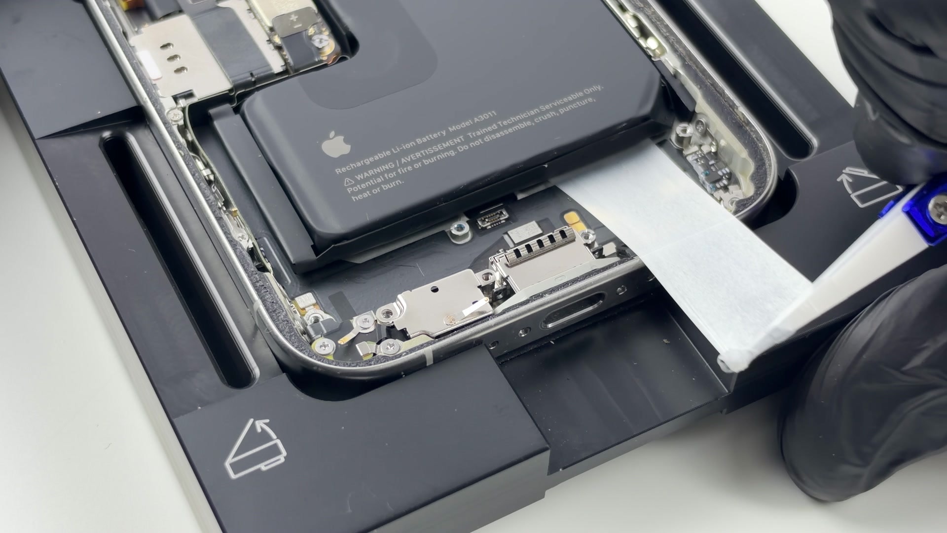 Vytahování lepicího pásku pod baterií iPhonu