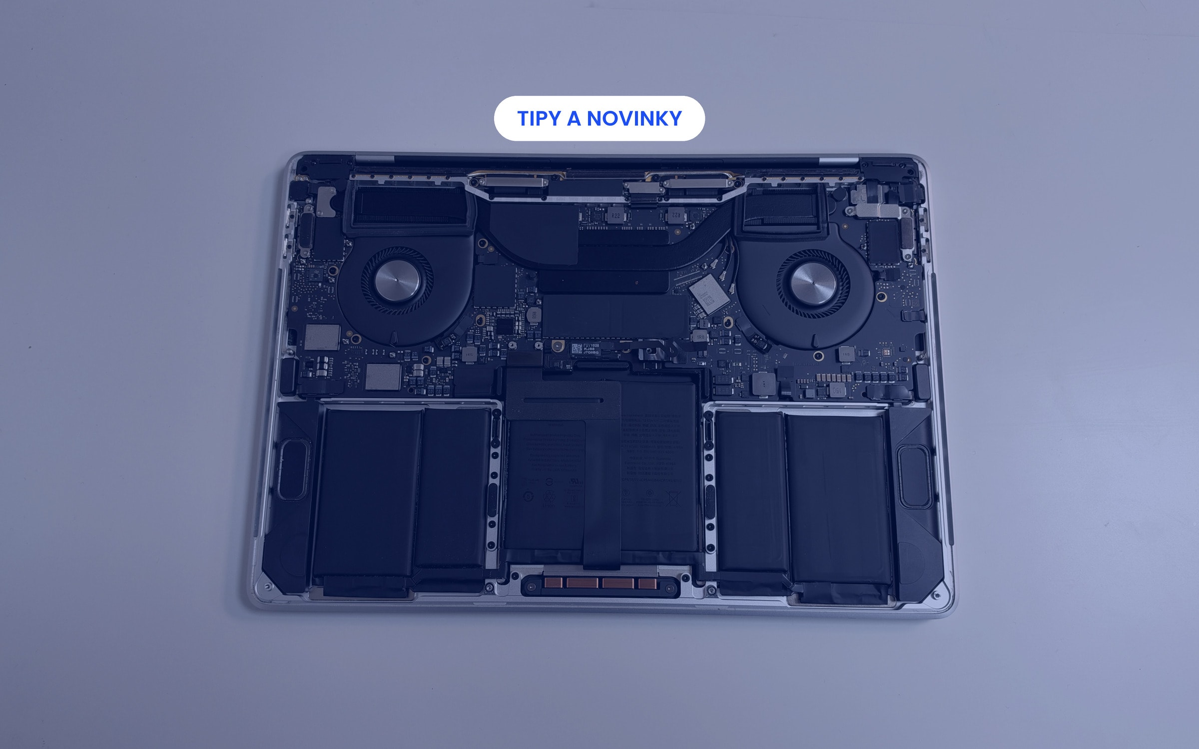 Otevřený MacBook s viditelnou baterií při servisu